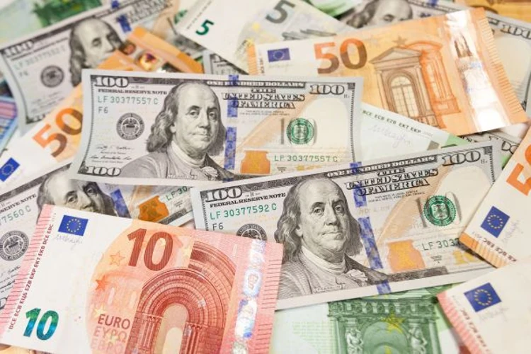 Банкноти долара, євро та злотого поряд із логотипом НБУ